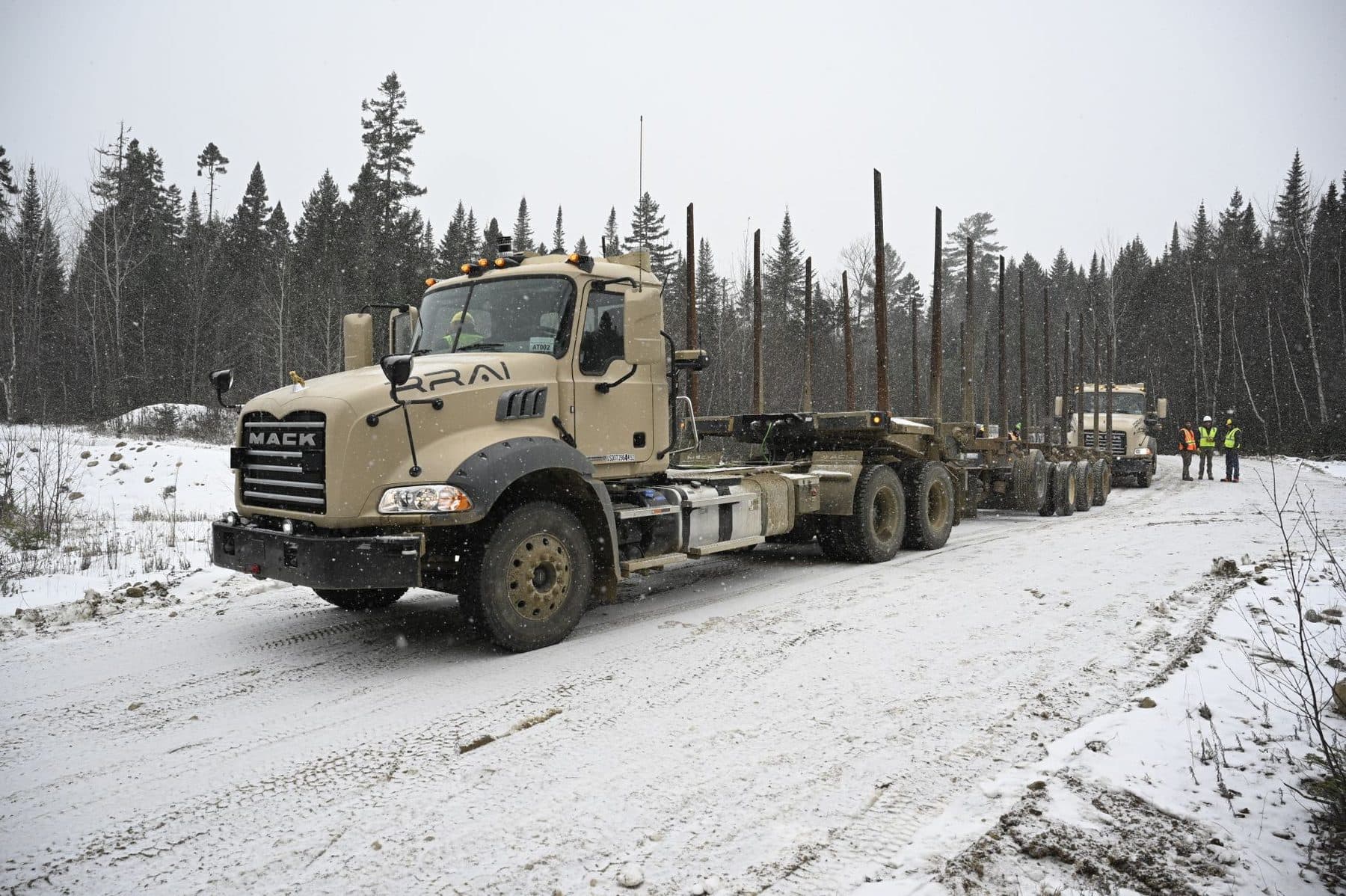 Automated logging truck loaded with timber on a snow-covered forest road